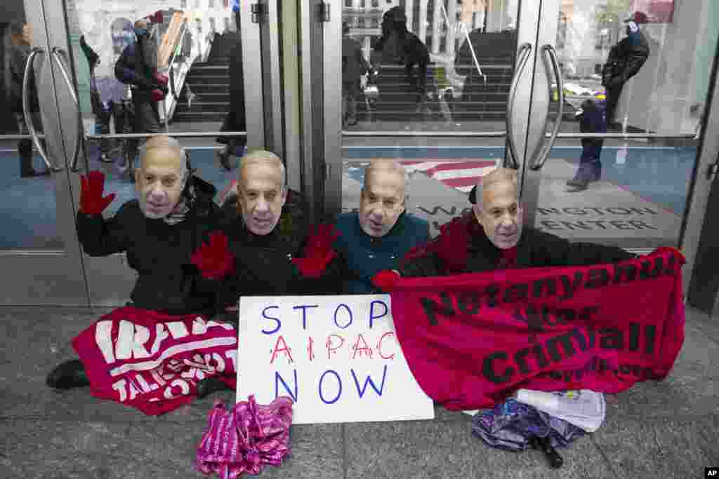 Para demonstran pro-Palestina yang dipimpin oleh Code Pink melakukan protes menggunakan topeng wajah Perdana Menteri Israel, Benjamin Netanyahu, di pintu masuk kantor Komite Urusan Publik Israel (AIPAC) di Washington (1/3). ​(AP/Cliff Owen)