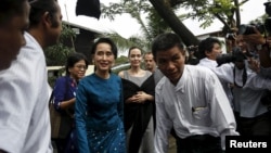 Pemimpin pro-demokrasi Myanmar Aung San Suu Kyi dan Utusan Khusus PBB urusan Pengungsi (UNHCR) Angelina Jolie Pitt tiba di hostel tempat tinggal para buruh perempuan di Kawasan Industri Hlaingtaryar, Yangon (1/8). (Reuters/Soe Zeya Tun)