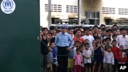 Ethnic Montagnards look from behind the gates of their temporary UNHCR (United Nations High Commission for Refugees) and IOM (International Organization for Migration) administered quarters in Phnom Penh, file photo. 
