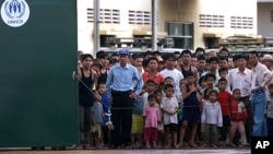 Ethnic Montagnards look from behind the gates of their temporary UNHCR (United Nations High Commission for Refugees) and IOM (International Organization for Migration) administered quarters in Phnom Penh, file photo. 