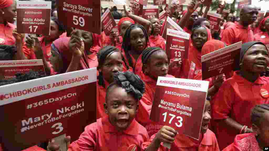 Gadis-gadis muda yang dikenal sebagai Duta Chibok, membawa plakat bertuliskan nama-nama siswi-siswi yang diculik dari SMP Neger di Chibok setahun sebelumnya, dalam demonstrasi di Abuja, 14 April 2015. (AP/Sunday Alamba)