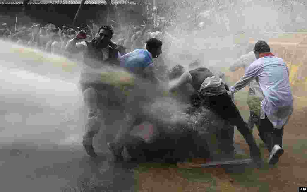 Police use water cannon to disperse protesters led by the opposition Congress party in New Delhi. Police fired water cannon at demonstrators rallying in the Indian capital against Prime Minister Narendra Modi&#39;s land reforms, which they say will harm the country&#39;s millions of farmers.