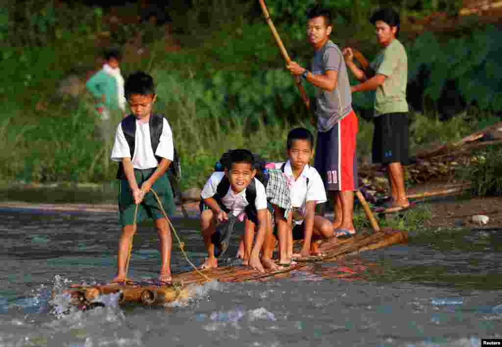 Schoolchildren ride on a makeshift raft to attend the opening of classes at a remote Casili Elementary School in Montalban, Rizal northeast of Manila, Philippines on June 13, 2016.