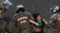 Policías antidisturbios detienen a un estudiante que participaba en las protestas en Santiago.