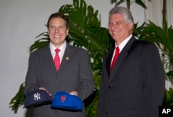 FILE - New York Governor Andrew Cuomo, left, poses for photos as he gives New York Yankees and Mets baseball caps to Cuba's First Vice President Miguel Diaz-Canel after their meeting at Revolution Palace in Havana, Cuba, April 21, 2015.