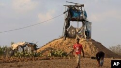 Palestinians inspect a military observation post that was hit by an Israeli tank shell east of Khan Younis, southern Gaza Strip, July 20, 2018. Israel pummeled Hamas targets in Gaza killing four Palestinians Friday in a series of air strikes after gunmen shot at soldiers near the border, officials said. 