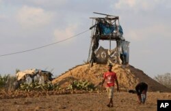 FILE - Palestinians inspect a military observation post that was hit by an Israeli tank shell east of Khan Younis, southern Gaza Strip, July 20, 2018. Israel pummeled Hamas targets in Gaza, killing four Palestinians, in a series of airstrikes after gunmen shot at soldiers near the border, officials said.