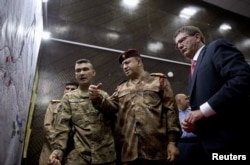 U.S. Defense Secretary Ash Carter, right, and Iraqi Lt. Gen. Abdul Amir al-Lami, center, look over diagrams and maps at the Combined Joint Operations Center in Baghdad, Iraq, July 23, 2015.