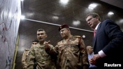 Menhan AS Ash Carter, (kanan) dan Letjen Abdul Amir al-Lami (tengah) mengamati diagram dan peta di Pusat Operasi Bersama Militer AS-Irak di Baghdad (23/7).