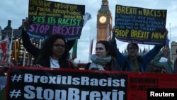 Des manifestants tiennent des pancartes lors d'une protestation en faveur d'amendements au projet de loi sur le Brexit à l’extérieur du Parlement britannique, à Londres, le 13 mars 2017.