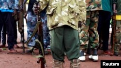 FILE - A former child soldier holds a gun during a release ceremony for child soldiers outside Yambio, South Sudan, Aug. 7, 2018.