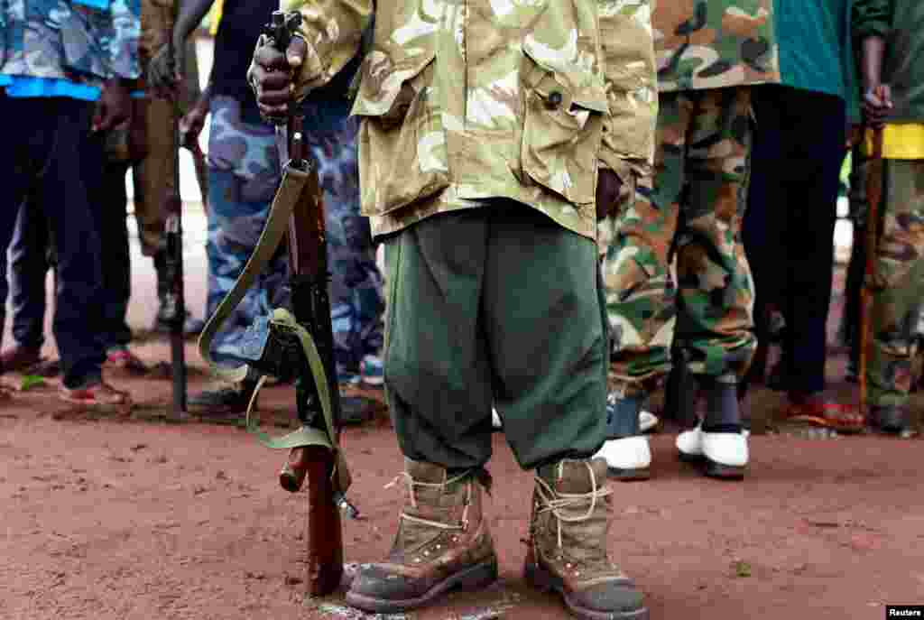 A former child soldier holds a gun while taking part in a child soldiers&#39; release ceremony, outside Yambio, South Sudan.