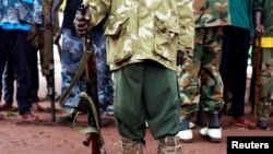 A former child soldier holds a gun as he and others participate in a child soldiers' release ceremony, outside Yambio, South Sudan, Aug. 7, 2018.