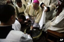 Archbishop Pierbattista Pizzaballa washes the foot of a priest during the Washing of the Feet ceremony at the Church of the Holy Sepulchre, traditionally believed by many Christians to be the site of the crucifixion and burial of Jesus Christ, in Jerusale