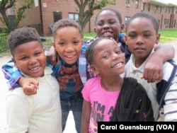 Some youngsters clamor to be photographed near McCulloh Homes, a housing project in Baltimore, Maryland.