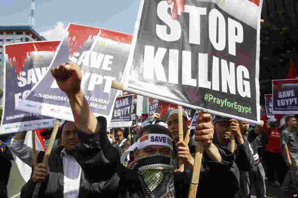 Indonesians hold posters during a protest calling for an end to the violence used against the supporters of ousted President Mohamed Morsi in Egypt, in Jakarta, Indonesia, Aug 16, 2013.