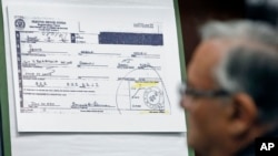 FILE- A copy of President Barack Obama's selective service card is displayed during a news conference in Phoenix, March 1, 2012, addressing the controversy surrounding his birth certificate.