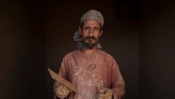 Mahmad Rizak, 38, poses for a photo as he plasters the walls of his house in Salar village, Wardak province, Afghanistan, Oct. 12, 2021.