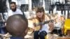 Musician Kelly Grevler gives guitar lessons to underprivileged children on a sidewalk in central Johannesburg. (D. Taylor/VOA)