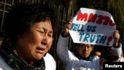Liu Guiqiu, whose son was onboard the missing Malaysia Airlines flight MH370, cries during a gathering of family members of the missing passengers outside the Malaysian embassy in Beijing, March 8, 2015. 