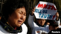 Liu Guiqiu, whose son was onboard the missing Malaysia Airlines flight MH370, cries during a gathering of family members of the missing passengers outside the Malaysian embassy in Beijing, March 8, 2015. 