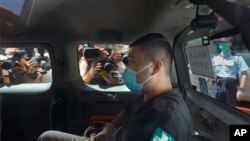 香港首位被控涉嫌違反國安法的唐英傑（Tong Ying-kit）坐著輪椅由警車押解至法院應訊。（2020年7月6日）