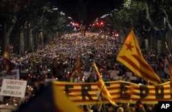 FILE - People gather to protest against the National Court's decision to imprison civil society leaders without bail, in Barcelona, Spain, Oct. 17, 2017.