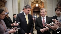 Senator Joe Manchin, left, and Senator Mark Kirk comment as the Senate approves legislation that extends Social Security payroll tax cuts for two months, at the Capitol in Washington, December 17, 2011.