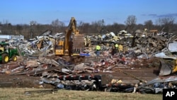 Emergency response workers dig through the rubble of the Mayfield Consumer Products candle factory in Mayfield, Ky., Dec. 11, 2021.