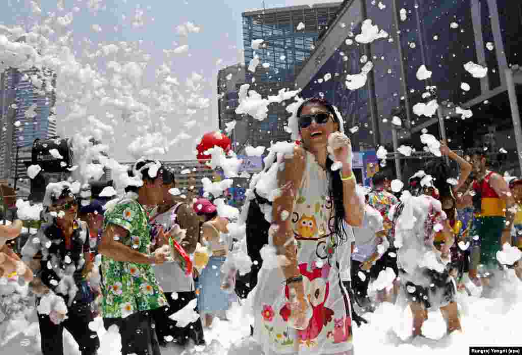 Foreign and Thai revelers dance amid foam during a foam party, a part of the annual Songkran celebration, the Thai traditional New Year also known as the water festival in Bangkok, Thailand.