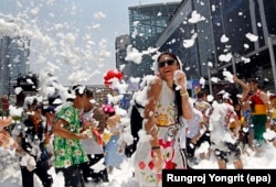 FILE - Foreign and Thai revelers dance amid foam during a foam party as part of the annual Songkran celebration, the Thai traditional New Year also known as the water festival in Bangkok, Thailand.