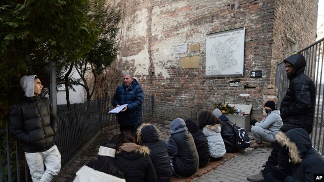 资料照：以色列大学生在华沙犹太区一面残墙下学习历史。