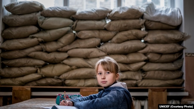 Lera Nagormay, 10, duduk untuk berfoto di ruang kelas di sekolah di Marinka, Oblast Donetsk, Ukraina, Rabu 22 November 2017. (Foto: UNICEF)
