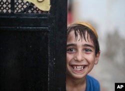 A student covering his head with a Kippah grins for the camera as he leaves the main Talmudic school at Hara Kbira, on the island of Djerba, southern Tunisia, Oct. 29, 2015..