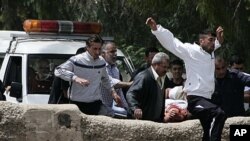 Syrians carry an injured man as they cross the border, in the Wadi Khaled area, about one kilometer (0.6 miles) from the Lebanon-Syria border, north Lebanon, May 14, 2011