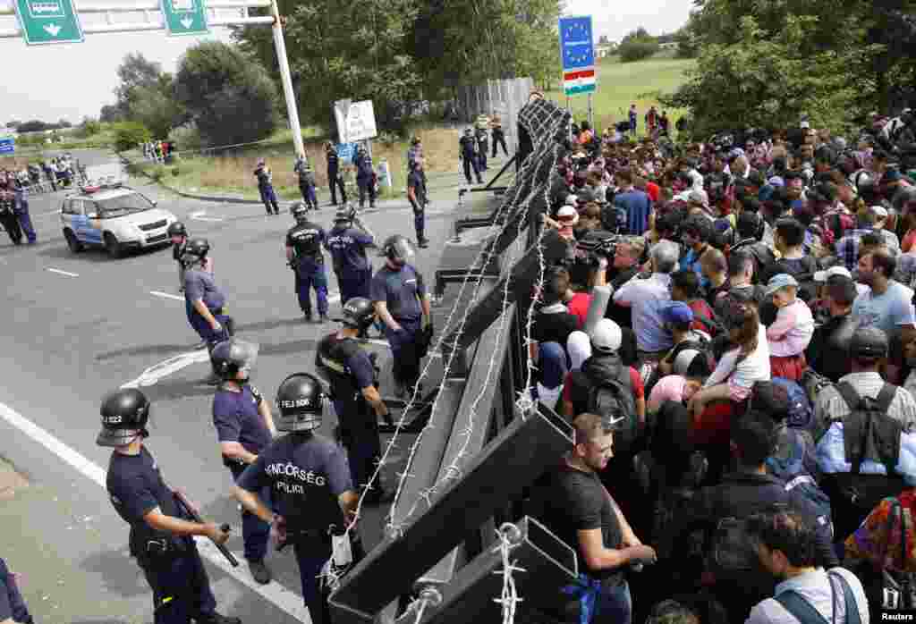 Migrants stand in front of a barrier at the border with Hungary near the village of Horgos, Serbia. Hundreds of migrants pressed against a barrier erected by Hungarian police across the main highway linking Serbia and Hungary, demanding they be allowed to cross the border.