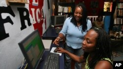 Ciata Victor, who is a Liberian returnee, instructs an unidentified lady inside her Internet cafe in Monrovia, (File photo).