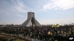 Iranians listen to speech of President Hassan Rouhani during a rally to commemorate the anniversary of the 1979 Islamic revolution under the Azadi (Freedom) monument tower in Tehran, Iran, Thursday, Feb. 11, 2016.