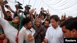 Imran Khan (2nd R), chairman of the Pakistan Tehreek-e-Insaf (PTI) political party, gestures to clear the way among supporters during a campaign meeting ahead of general elections in Karachi, Pakistan, July 4, 2018. 