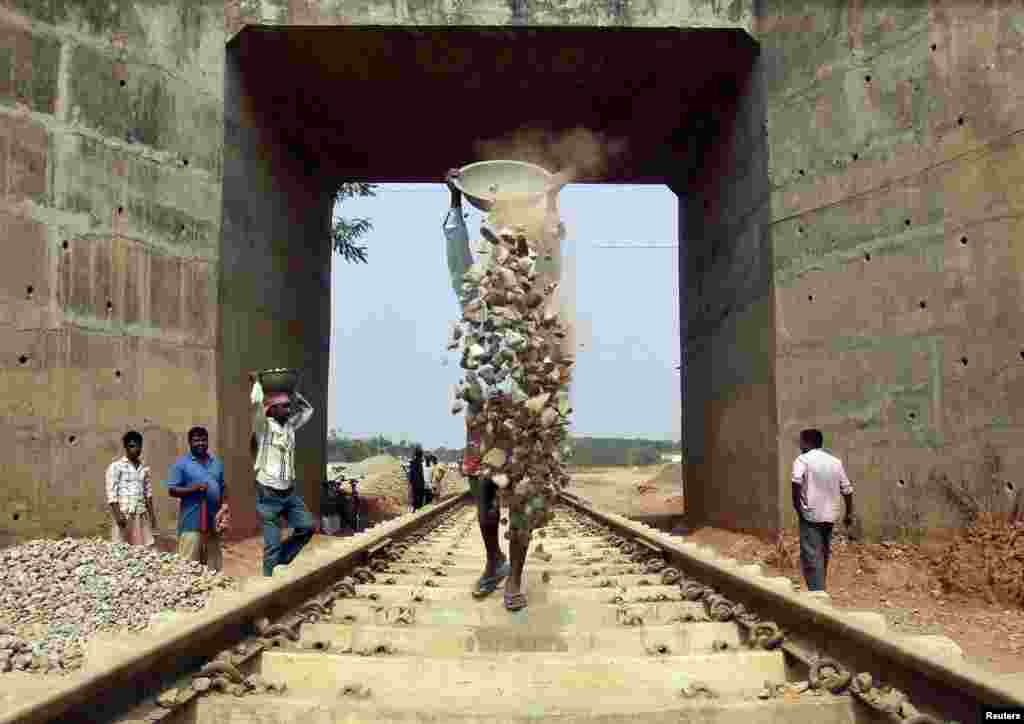 Laborers work at the installation site of a new railway track on the outskirts of Agartala, capital of India&#39;s northeastern state of Tripura.