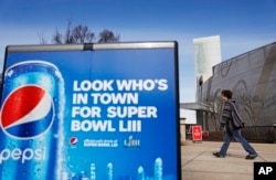 A Pepsi advertisement stands outside the World of Coca-Cola museum in Atlanta, Jan. 30, 2019. The Patriots and the Rams aren't the only ones battling for Super Bowl supremacy this week. Pepsi and Coke also seem to be squaring off. Pepsi, an official NFL sponsor of Super Bowl 53, has invaded Coke's home turf, its headquarters are in Atlanta.