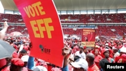 Supporters of South Africa's radical left-wing party, the Economic Freedom Fighters, hold a placard during the launch of the party's election manifesto in Soshanguve, near Pretoria, South Africa, Feb. 2, 2019.