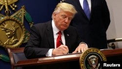 US President Donald Trump signs an executive order to impose tighter vetting of travelers entering the United States, at the Pentagon in Washington, Jan. 27, 2017. 
