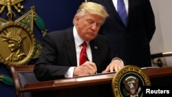 US President Donald Trump signs an executive order to impose tighter vetting of travelers entering the United States, at the Pentagon in Washington, Jan. 27, 2017. 