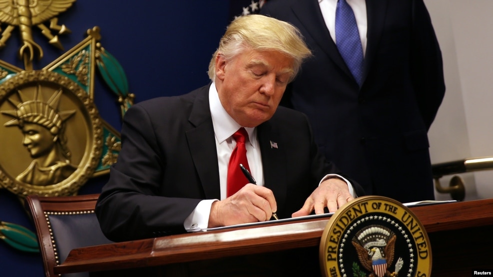 US President Donald Trump signs an executive order to impose tighter vetting of travelers entering the United States, at the Pentagon in Washington, Jan. 27, 2017. 
