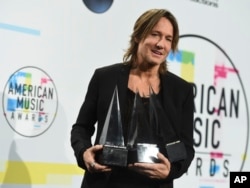 Keith Urban poses in the press room with the awards for favorite male artist country, favorite song country for "Blue Ain't Your Color" and favorite album country for "Ripcord" at the American Music Awards at the Microsoft Theater on Sunday, Nov. 19, 2017