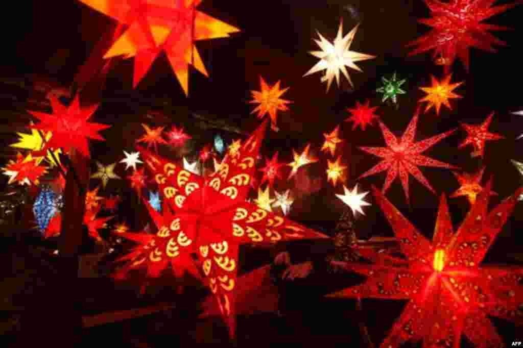 A vendor for Christmas stars waits for customers at the Christmas market on the Alexanderplatz in Berlin on Monday, Nov. 22, 2010. The Christmas markets in Berlin open on Monday for the Christmas season. (AP Photo/Markus Schreiber)