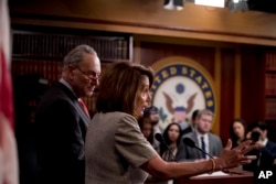 House Speaker Nancy Pelosi of Calif., accompanied by Senate Minority Leader Sen. Chuck Schumer of N.Y., left, speaks at a news conference on Capitol Hill in Washington, Jan. 25, 2019, after President Donald Trump announces a deal to reopen the government for three weeks.
