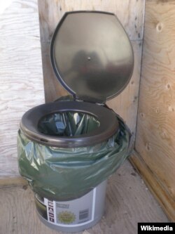 An indoor 'honey bucket,' a plastic bucket fitted with a toilet seat for comfort and a plastic bag for waste containment.