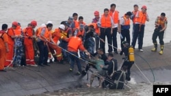A 65-year-old woman, center, is rescued by divers from the Dongfangzhixing or "Eastern Star" vessel which sank in the Yangtze river in Jianli, central China's Hubei province, June 2, 2015. (AFP Photo)